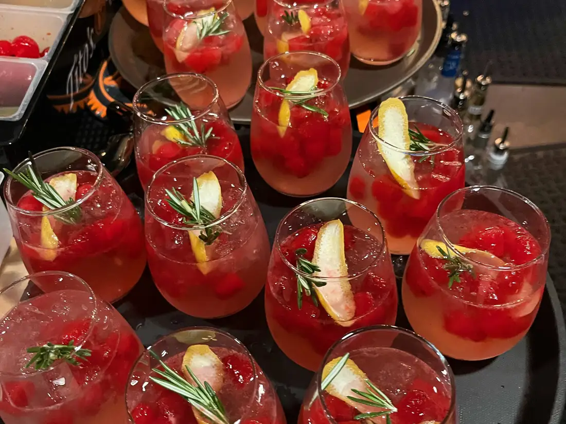collection of holiday cocktails with rosemary and orange garnishes